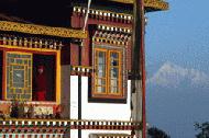 A Buddist monk peers out the window on a beautiful morning in Darjeeling with Kanchenjunga in the background