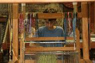 Peter utilizes a loom to create a work of art